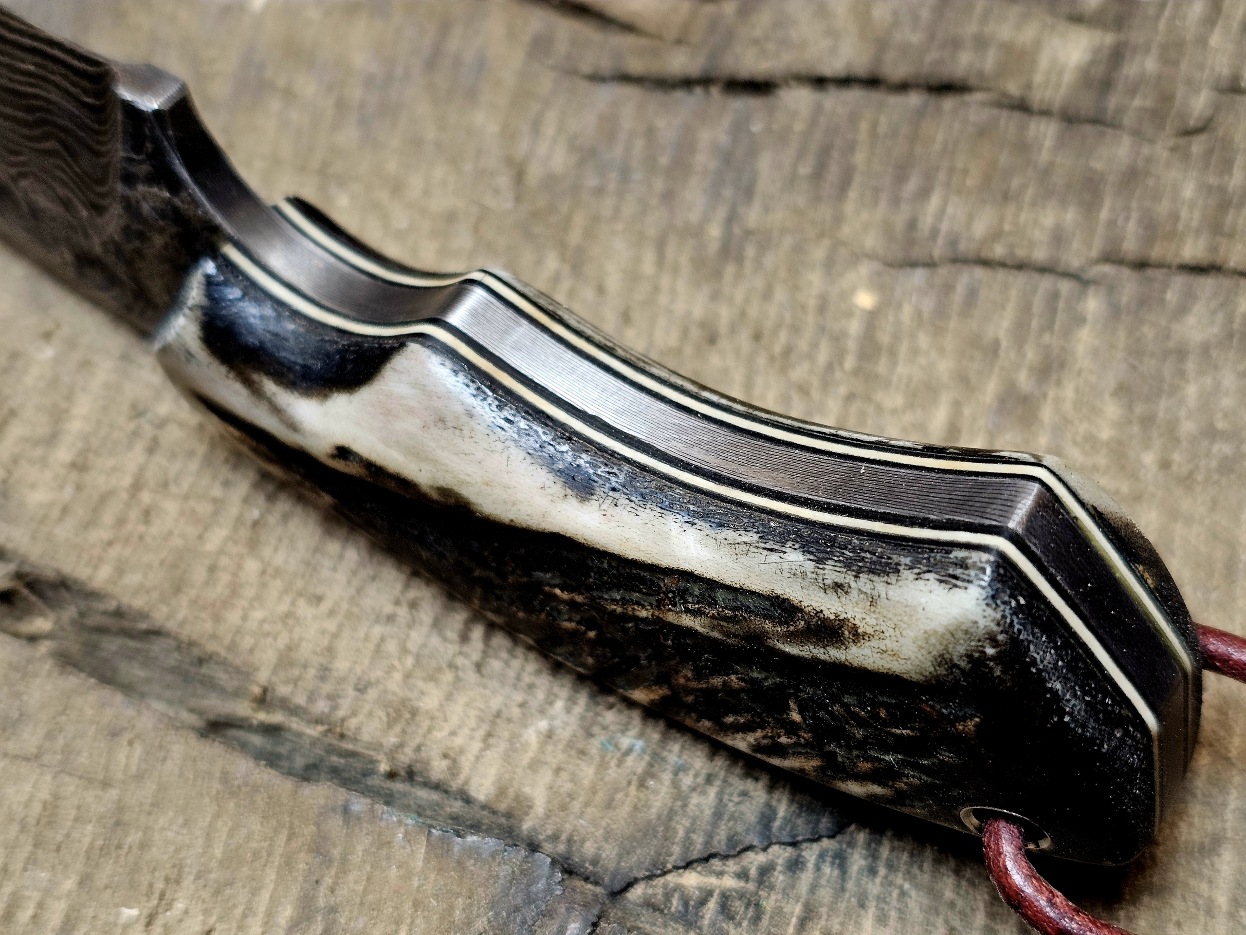 Seitliche Detailaufnahme Hirschhorngriff mit Lagenaufbau Damast Jagdmesser