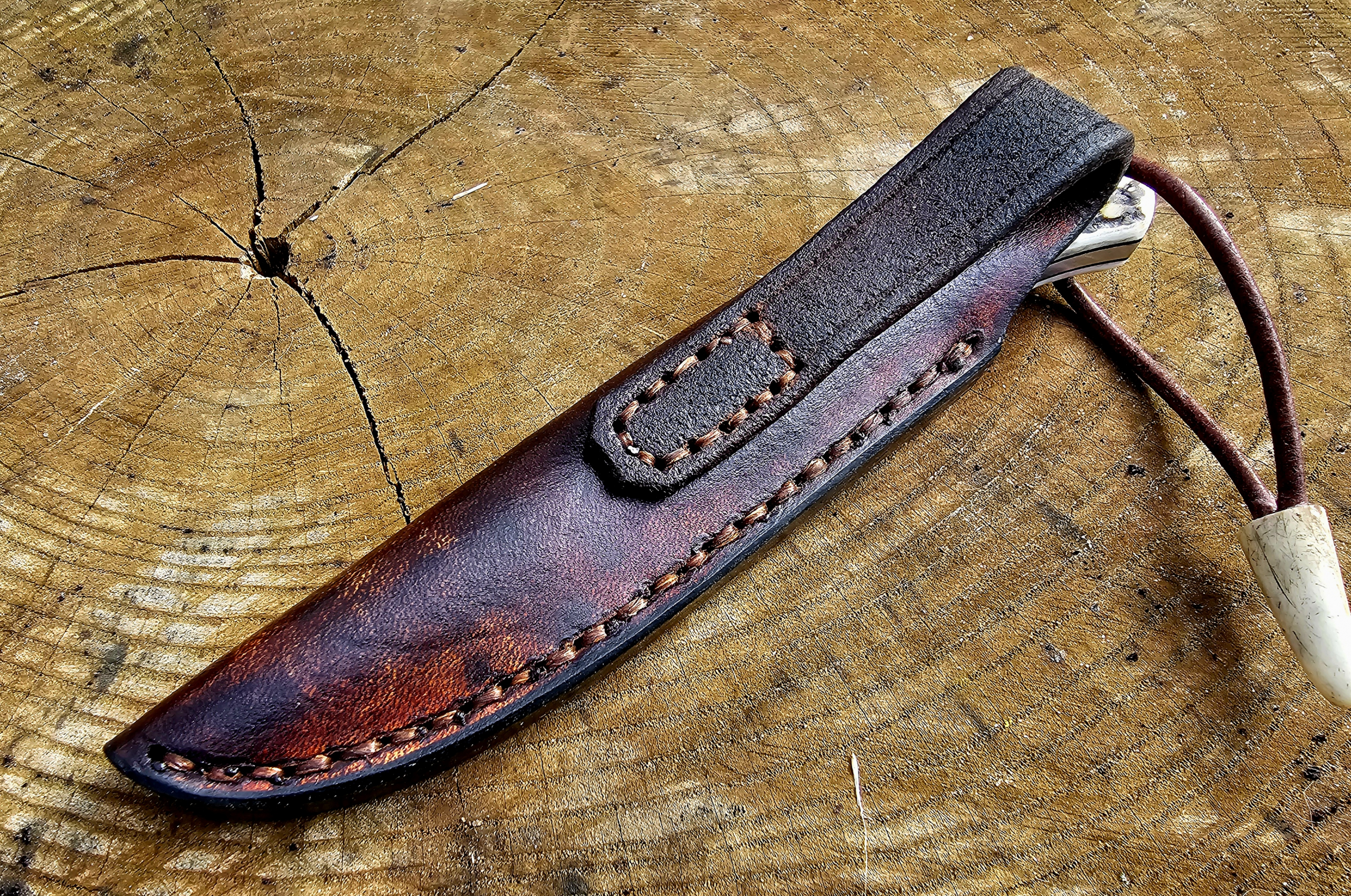 Detailaufnahme einer handgenähten Lederscheide für ein Jagdmesser