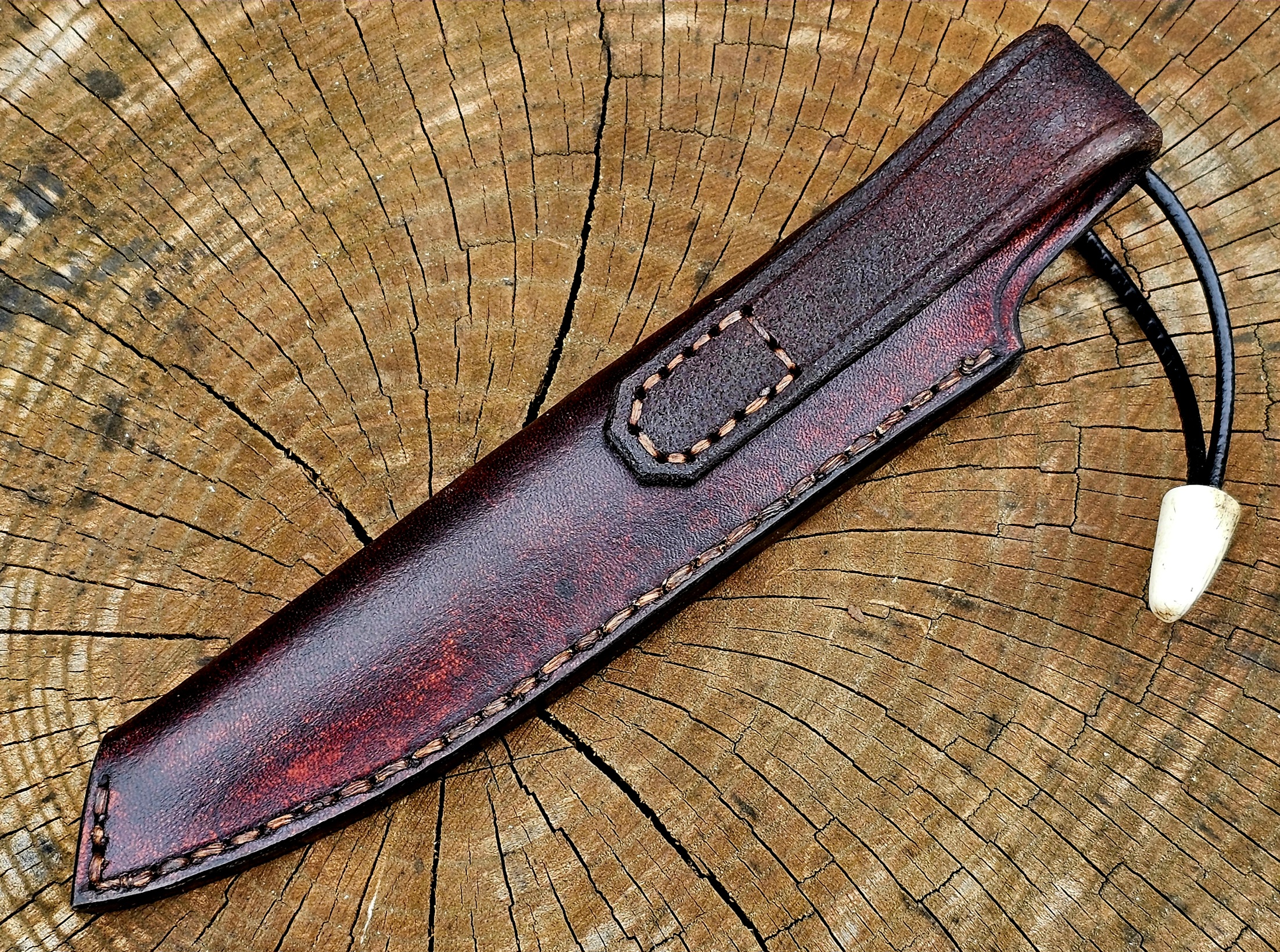 Handgefertigte braune Lederscheide vom Boreas Messer mit sauberer Sattlernaht und Fangriemen aus Leder
