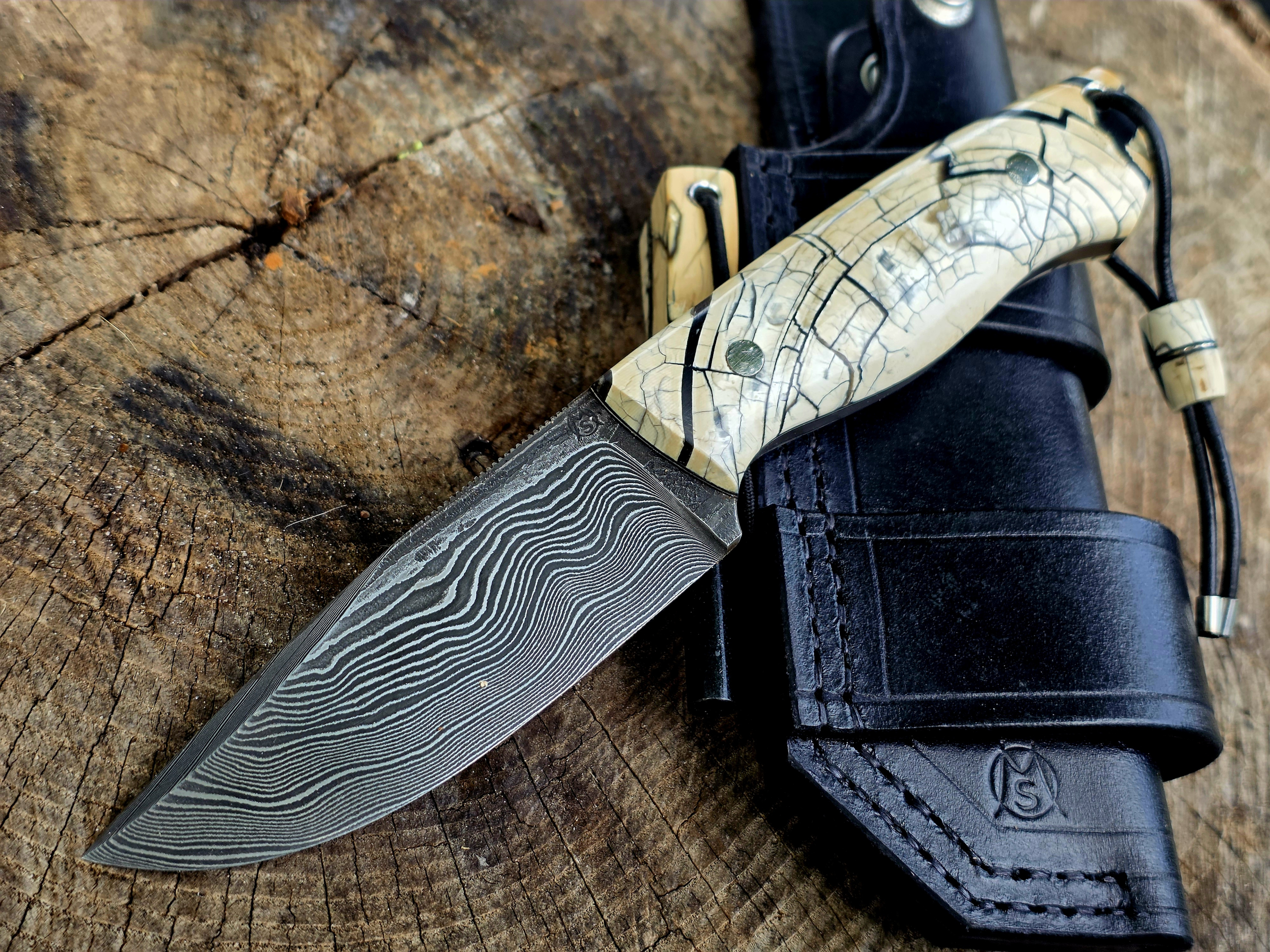 Bady K – Exklusives Bushcraftmesser aus Damast und Mammutelfenbein Handgefertigtes Bady K Bushcraftmesser mit Paschinger-Damastklinge, stabilisiertem Mammutelfenbein-Griff und schwarzer Bushcraft-Lederscheide.
