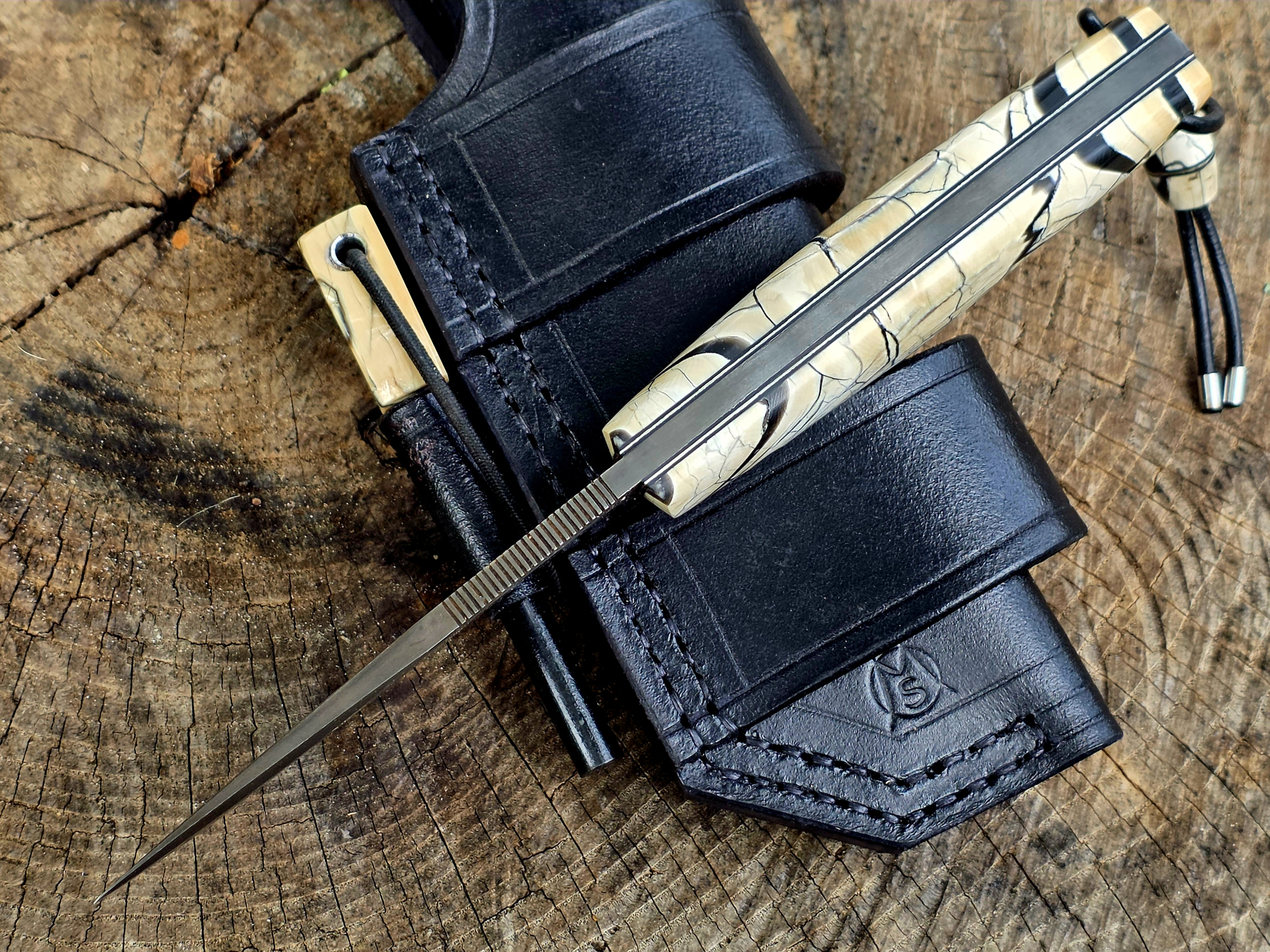 Bady K – Klingenrücken und Mammutelfenbein-Griff – Meyers Messer Bady K Bushcraftmesser mit Mammutelfenbein-Griffschalen, durchgehendem Erl und Daumenriffelung auf schwarzer Bushcraftscheide