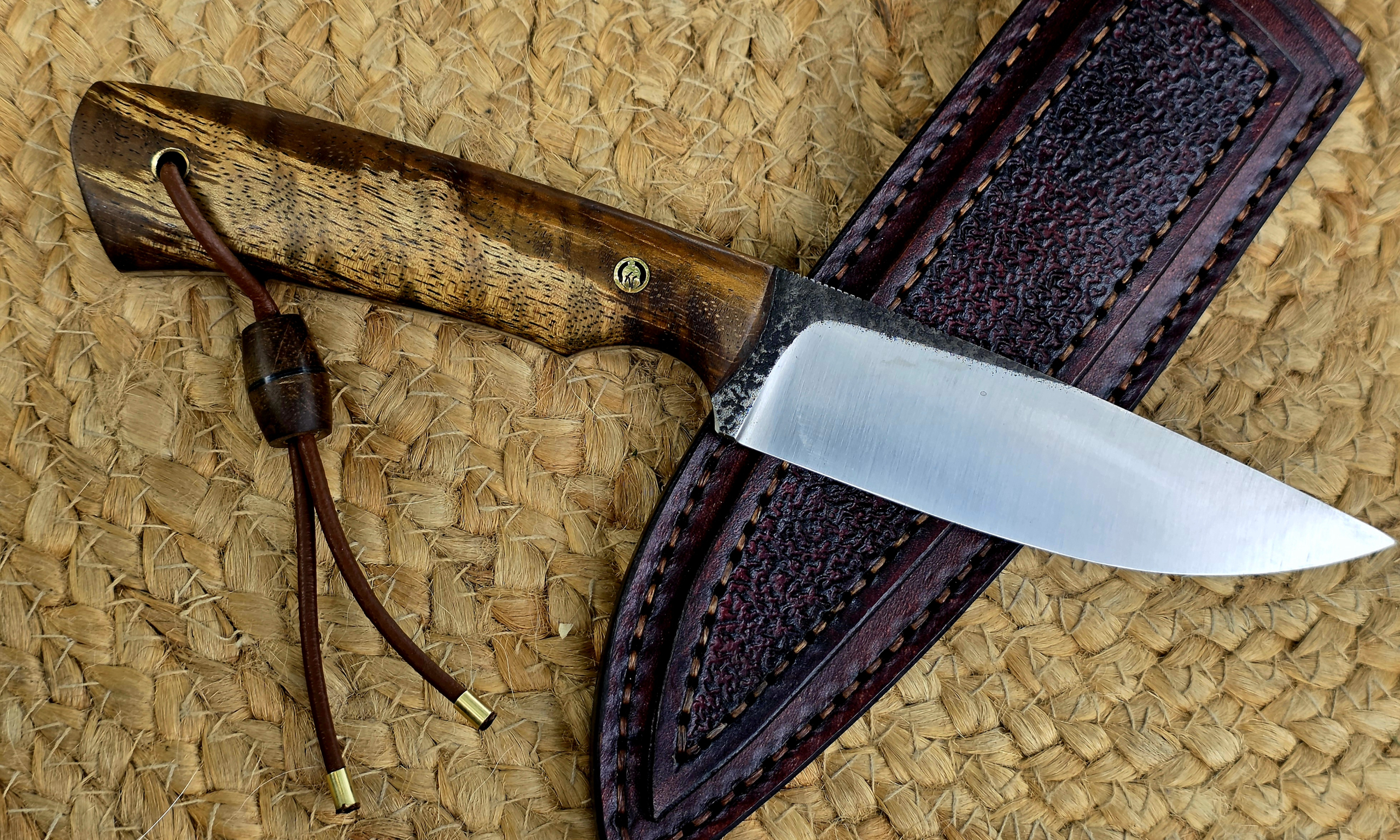 Shor 2.0 Messer mit Curly-Mango-Griff, Lederfangriemen und dunkelbrauner Lederscheide in der Seitenansicht